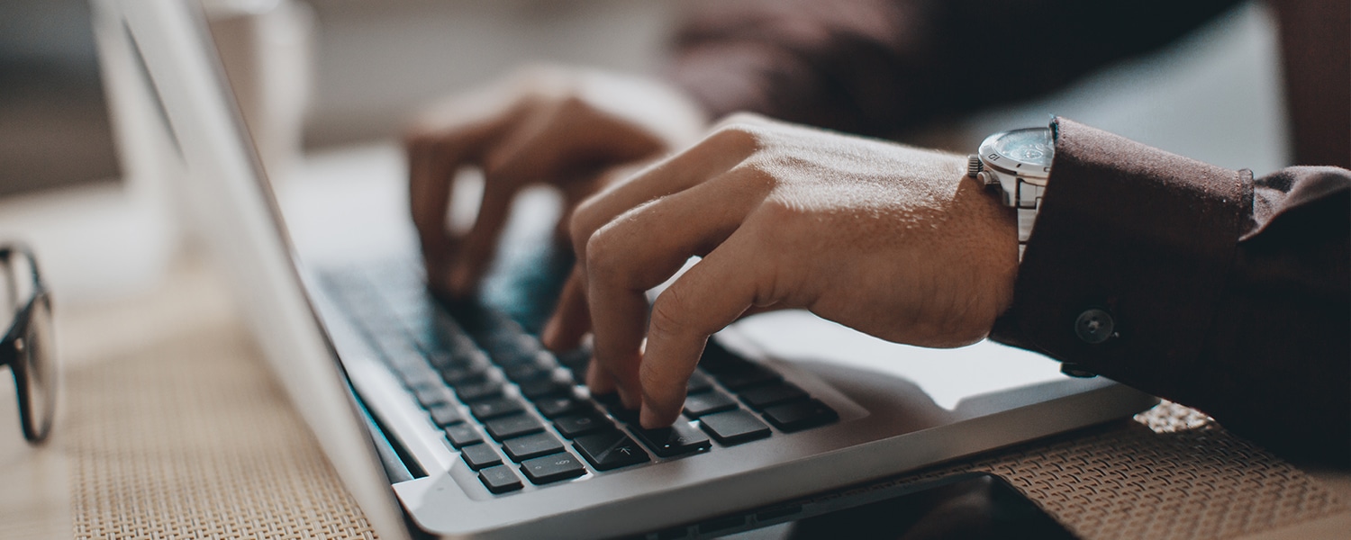 How to Pick an Outsourced Marketing Agency | Man Types at Laptop