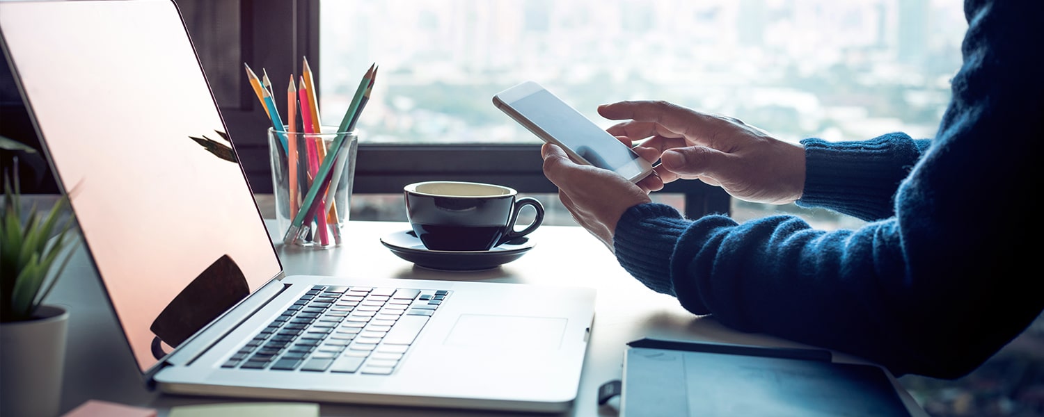 What Are the Best Outsourced Marketing Companies? | Man At Laptop with Phone